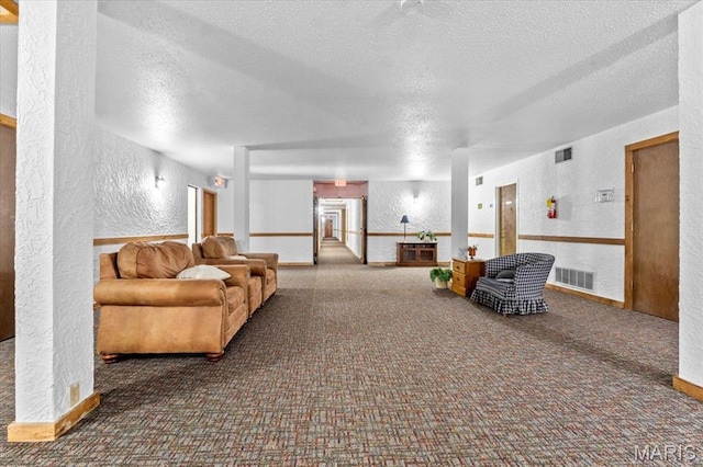 building lobby featuring a textured wall and a textured ceiling