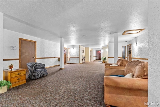 carpeted living area with a textured wall and a textured ceiling