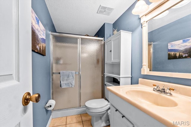 full bath with tile patterned floors, a shower stall, toilet, vanity, and a textured ceiling