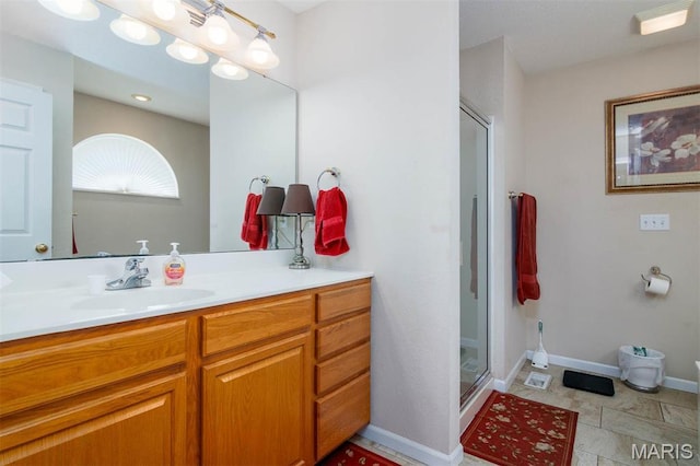 full bathroom with a stall shower, vanity, and baseboards
