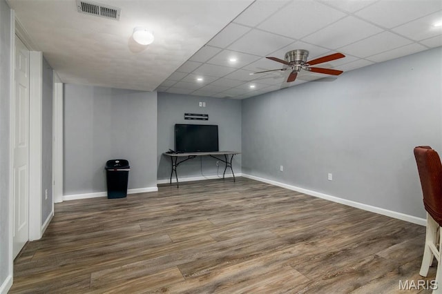 unfurnished living room featuring wood finished floors, a ceiling fan, baseboards, recessed lighting, and a drop ceiling