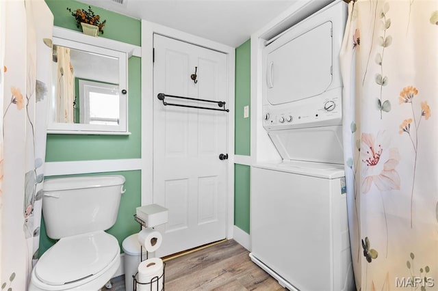 5704 Feezor Rd, Farmington, MO 63640 - bathroom featuring estacked washer and dryer, toilet, wood finished floors, and a shower with curtain