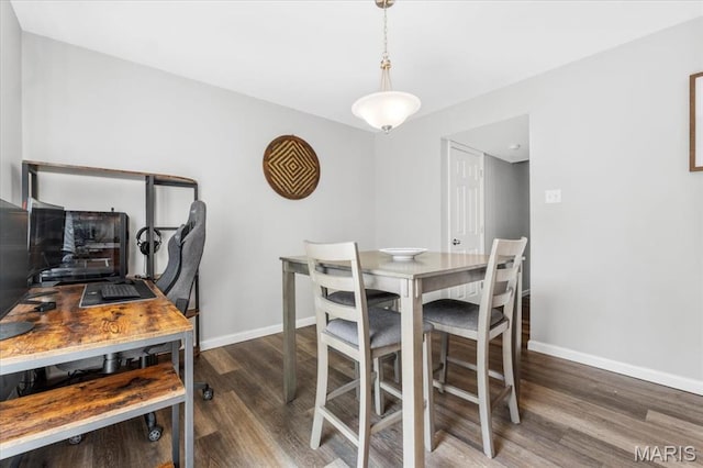 dining area featuring wood finished floors, baseboards, and a desk