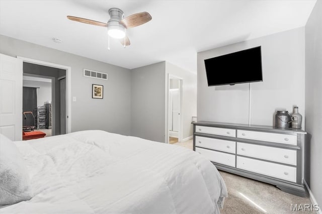 bedroom with light colored carpet, baseboards, ceiling fan, and connected bathroom