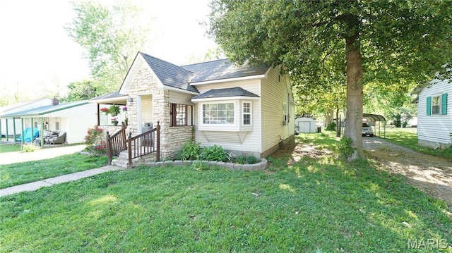 811 N Catalpa St, Dexter, MO 63841 - view of front of house with a storage shed, a front yard, an outbuilding, a detached carport, and driveway