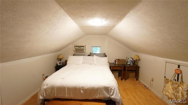 811 N Catalpa St, Dexter, MO 63841 - bedroom featuring a textured ceiling, wood finished floors, baseboards, lofted ceiling, and an AC wall unit