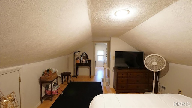 811 N Catalpa St, Dexter, MO 63841 - bedroom featuring a textured ceiling, wood finished floors, vaulted ceiling, and baseboards