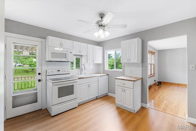1522 S Elm Ave, Saint Louis, MO 63119 - kitchen featuring white appliances, a sink, white cabinets, tasteful backsplash, and light wood-type flooring
