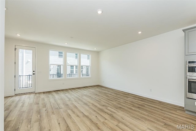 unfurnished living room with light wood-style flooring, baseboards, and recessed lighting
