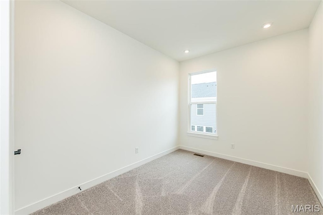 empty room with baseboards, light carpet, and recessed lighting