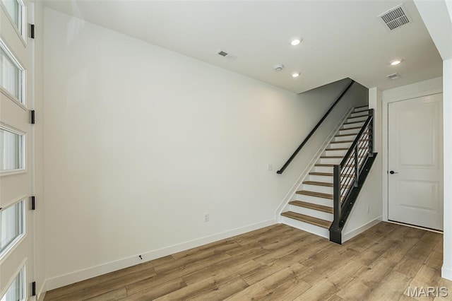interior space with stairs, light wood finished floors, recessed lighting, and baseboards