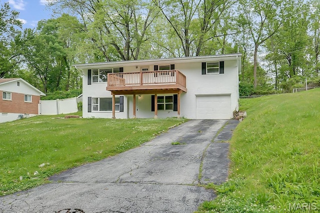 view of front of home featuring an attached garage, asphalt driveway, stucco siding, and a wooden deck