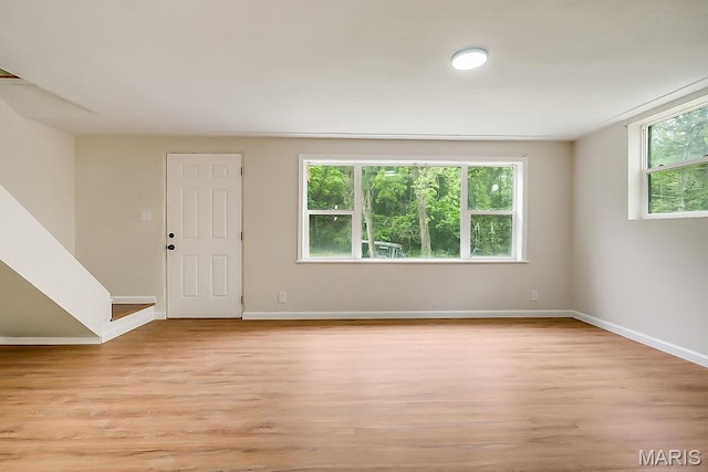 unfurnished room with plenty of natural light, light wood-style flooring, and baseboards