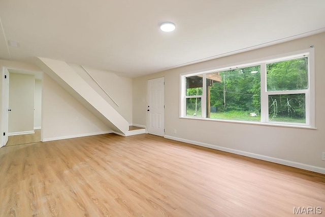 bonus room featuring light wood finished floors, plenty of natural light, and baseboards