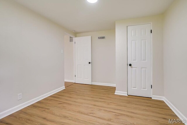 empty room featuring light wood-type flooring and baseboards