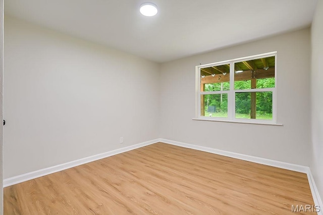 unfurnished room with baseboards and light wood-style flooring
