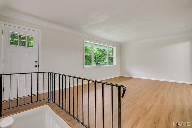 stairs featuring healthy amount of natural light, wood finished floors, and baseboards