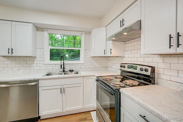 kitchen featuring stainless steel appliances, a sink, under cabinet range hood, and light countertops