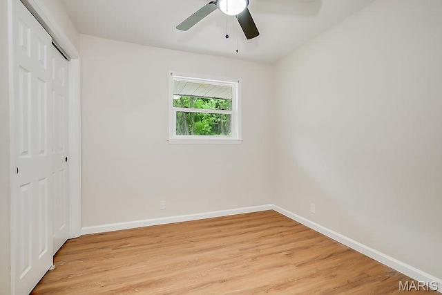 unfurnished bedroom with a closet, light wood-style flooring, baseboards, and ceiling fan