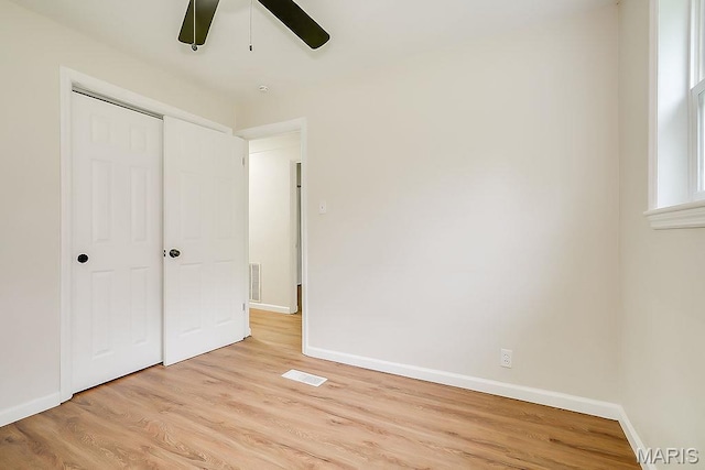 unfurnished bedroom featuring light wood-type flooring, baseboards, and a closet