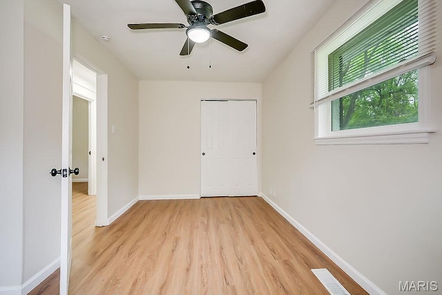 unfurnished bedroom with light wood finished floors, baseboards, a closet, and a ceiling fan