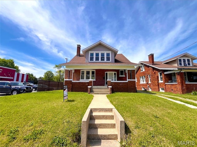 bungalow with covered porch, a chimney, a front yard, and brick siding