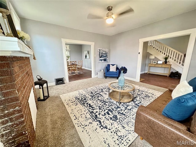 living area featuring a ceiling fan, carpet, stairway, and baseboards