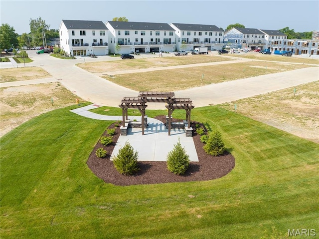 view of property's community featuring a pergola, a lawn, and a residential view