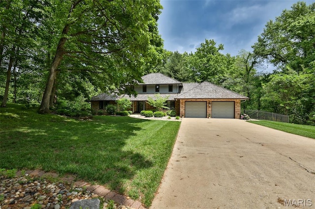 1989 Dogwood Trl, Collinsville, IL 62234 - view of front of home featuring an attached garage, brick siding, driveway, and a forest view