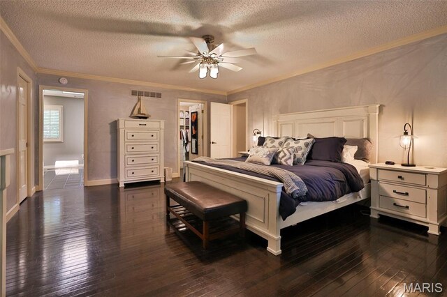 1989 Dogwood Trl, Collinsville, IL 62234 - bedroom featuring crown molding, a textured ceiling, dark wood-style floors, ceiling fan, and a walk in closet