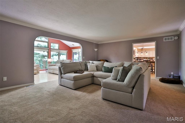 1989 Dogwood Trl, Collinsville, IL 62234 - living room featuring carpet flooring, a textured ceiling, a chandelier, ornamental molding, and arched walkways
