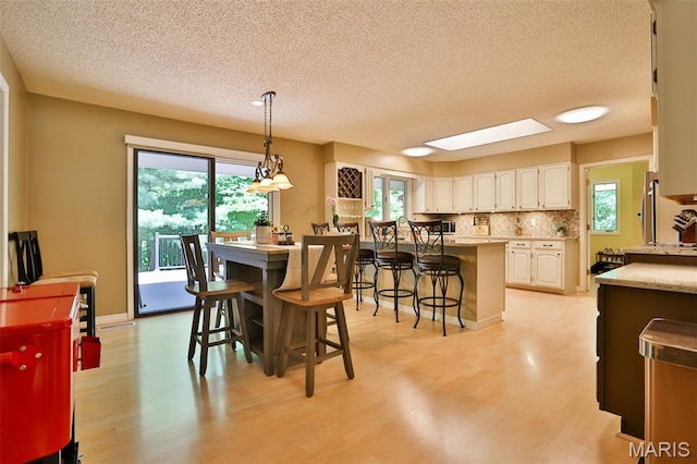 1989 Dogwood Trl, Collinsville, IL 62234 - dining room featuring light wood-style floors, a textured ceiling, and plenty of natural light