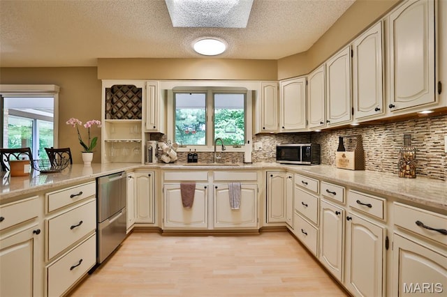 1989 Dogwood Trl, Collinsville, IL 62234 - kitchen with appliances with stainless steel finishes, healthy amount of natural light, a sink, tasteful backsplash, and a textured ceiling