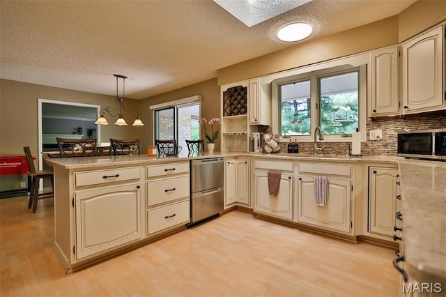 1989 Dogwood Trl, Collinsville, IL 62234 - kitchen with appliances with stainless steel finishes, a peninsula, a textured ceiling, light countertops, and light wood-style flooring