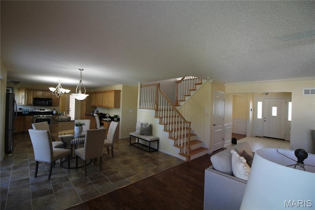 dining room featuring stairway, a textured ceiling, and a chandelier