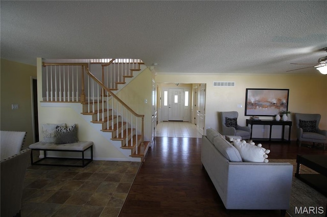 living room with a textured ceiling, stairway, ceiling fan, and wood finished floors