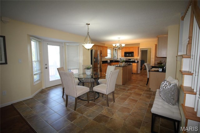dining area with a chandelier and baseboards