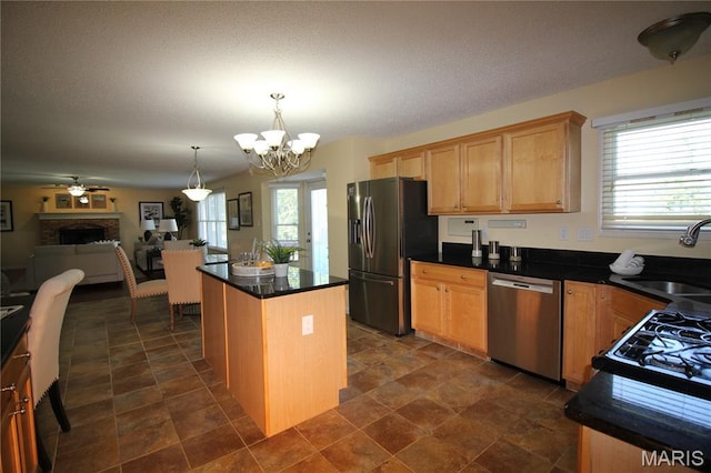 kitchen featuring appliances with stainless steel finishes, a sink, plenty of natural light, and a chandelier