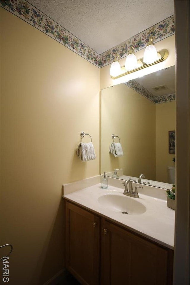 bathroom with a textured ceiling and vanity