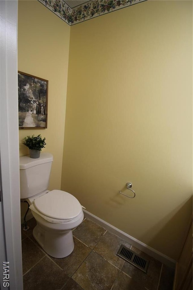 bathroom featuring baseboards and toilet