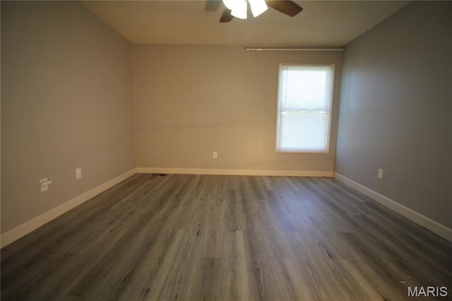 unfurnished room with ceiling fan, dark wood-style flooring, and baseboards