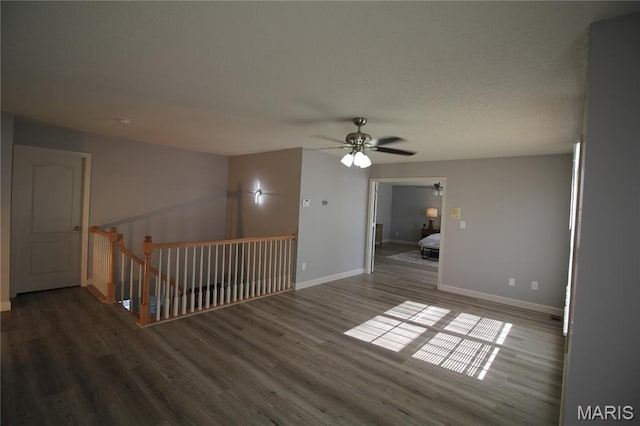 spare room with ceiling fan, wood finished floors, and baseboards