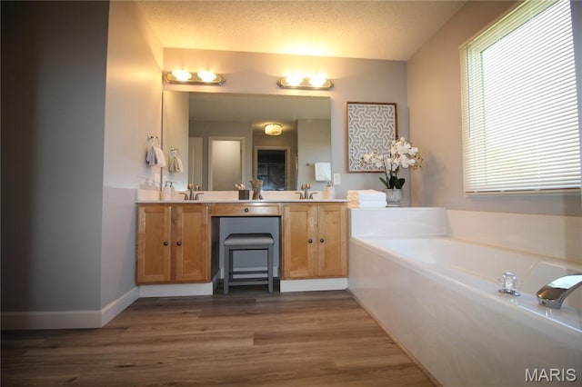 bathroom featuring double vanity, a garden tub, and wood finished floors