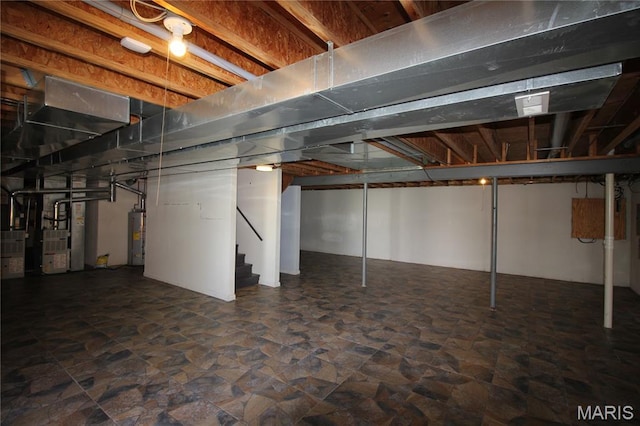below grade area with water heater, stairs, heating unit, and stone finish floors