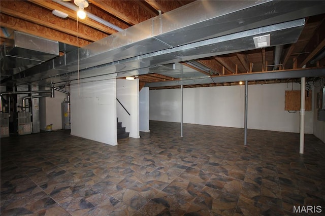 below grade area with gas water heater, stairway, stone finish floors, and heating unit