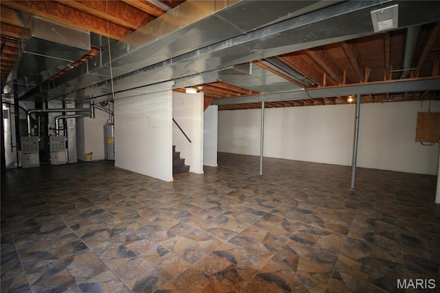 unfinished basement with water heater, stone finish flooring, stairs, and heating unit
