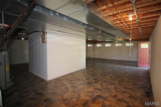 basement featuring water heater and stone finish floors