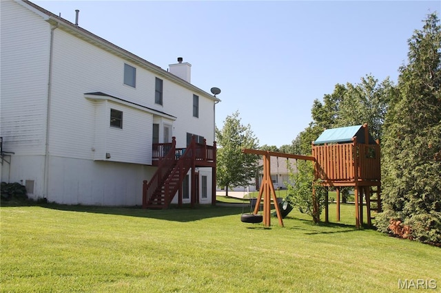 view of jungle gym featuring a yard, stairway, and a wooden deck