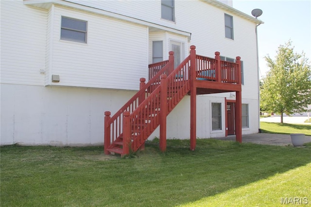 rear view of house with a lawn, stairs, and a wooden deck