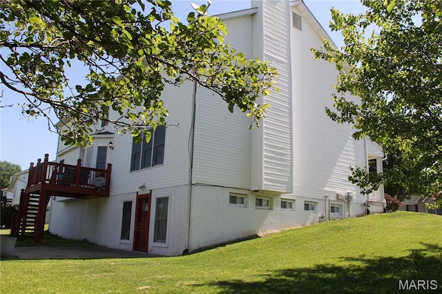 view of side of home featuring stairs, a yard, and a deck